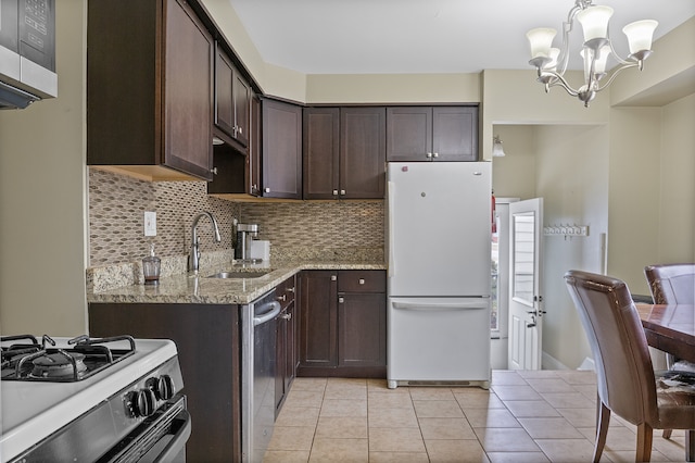 kitchen featuring tasteful backsplash, dark brown cabinets, light stone counters, appliances with stainless steel finishes, and a sink