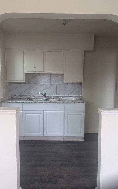 kitchen featuring a sink, arched walkways, and light countertops