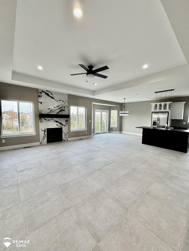 unfurnished living room featuring recessed lighting, plenty of natural light, ceiling fan, and baseboards