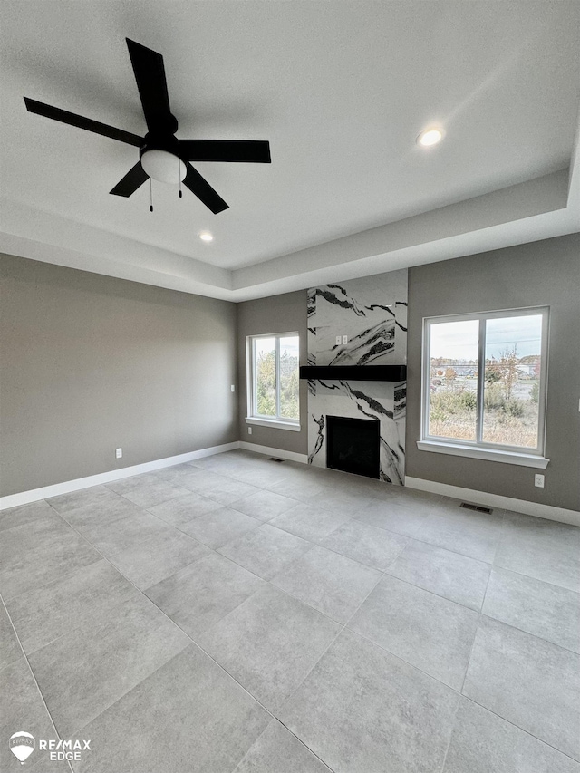 unfurnished living room with recessed lighting, a premium fireplace, baseboards, and visible vents