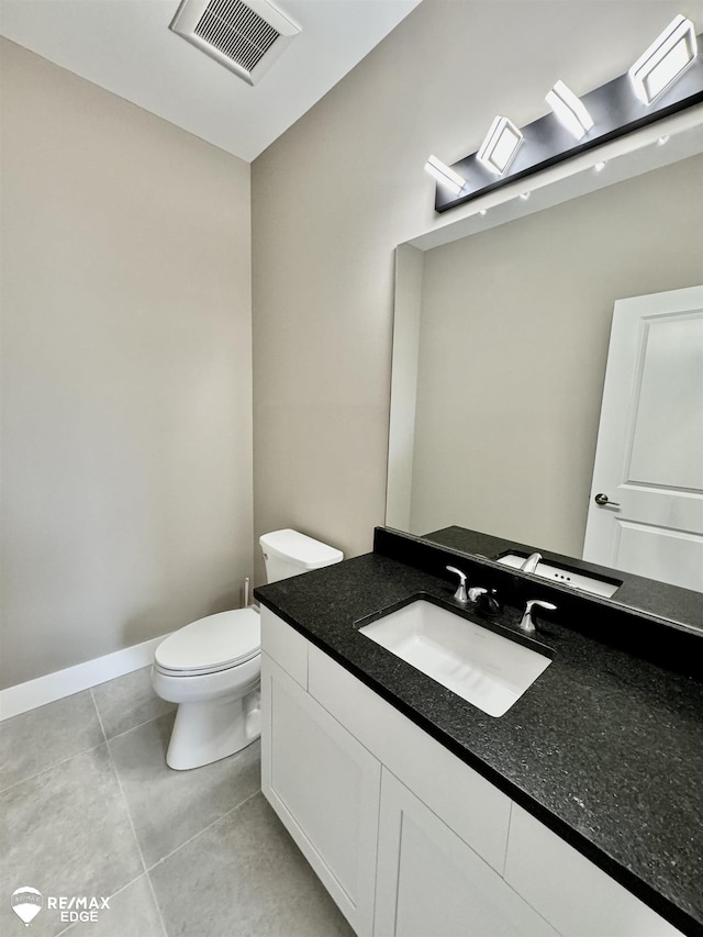 bathroom featuring visible vents, baseboards, toilet, tile patterned floors, and vanity