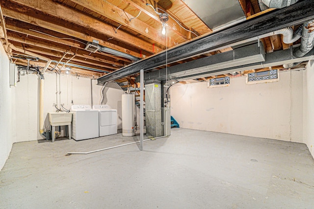 unfinished basement featuring water heater, heating unit, independent washer and dryer, and a sink