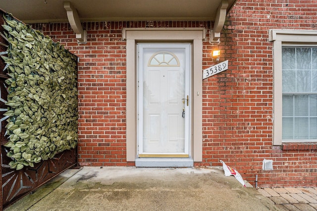 doorway to property with brick siding