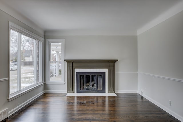 unfurnished living room with a fireplace with flush hearth, a healthy amount of sunlight, dark wood-type flooring, and baseboards