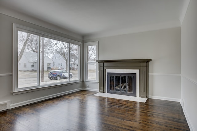 unfurnished living room with a fireplace with flush hearth, wood finished floors, and baseboards