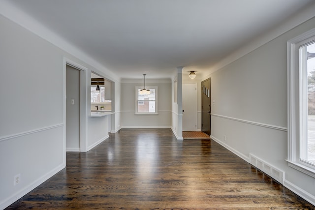 unfurnished living room featuring dark wood-style floors, visible vents, and baseboards