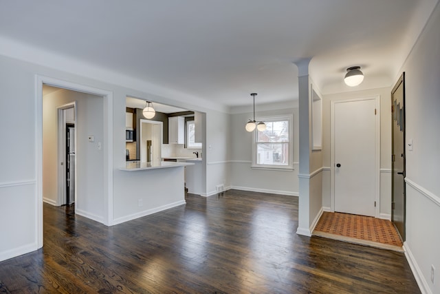 interior space with baseboards and dark wood-style flooring