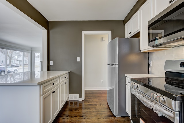 kitchen with stainless steel appliances, dark wood-type flooring, light countertops, and white cabinetry