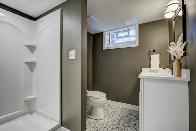 bathroom with a walk in shower, toilet, vanity, and baseboards