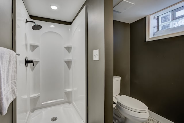 bathroom featuring a shower stall, toilet, and baseboards