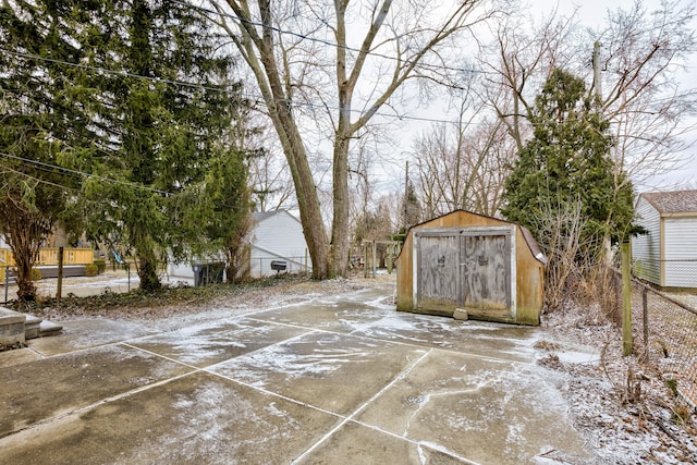 view of patio / terrace featuring a storage unit, an outdoor structure, and fence