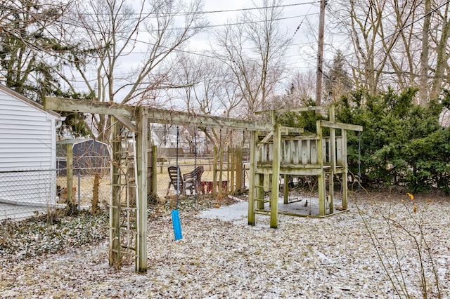 view of yard featuring fence, an outbuilding, and a playground