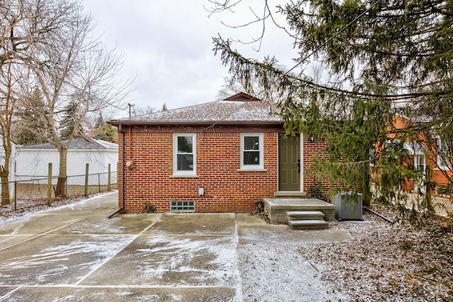 back of house featuring a patio area, brick siding, and fence