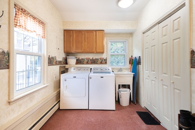 washroom featuring cabinet space, a baseboard radiator, and washing machine and clothes dryer