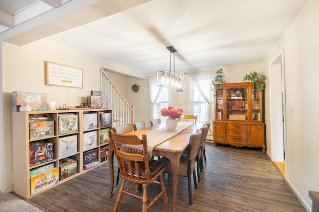 dining space featuring stairs, an inviting chandelier, and dark wood-style flooring