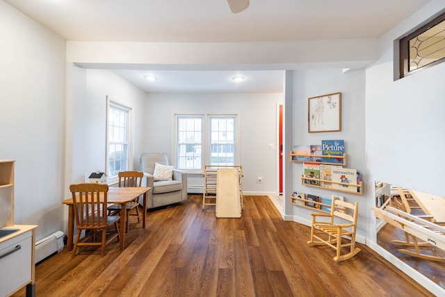 living area featuring dark wood-style floors, baseboards, and baseboard heating