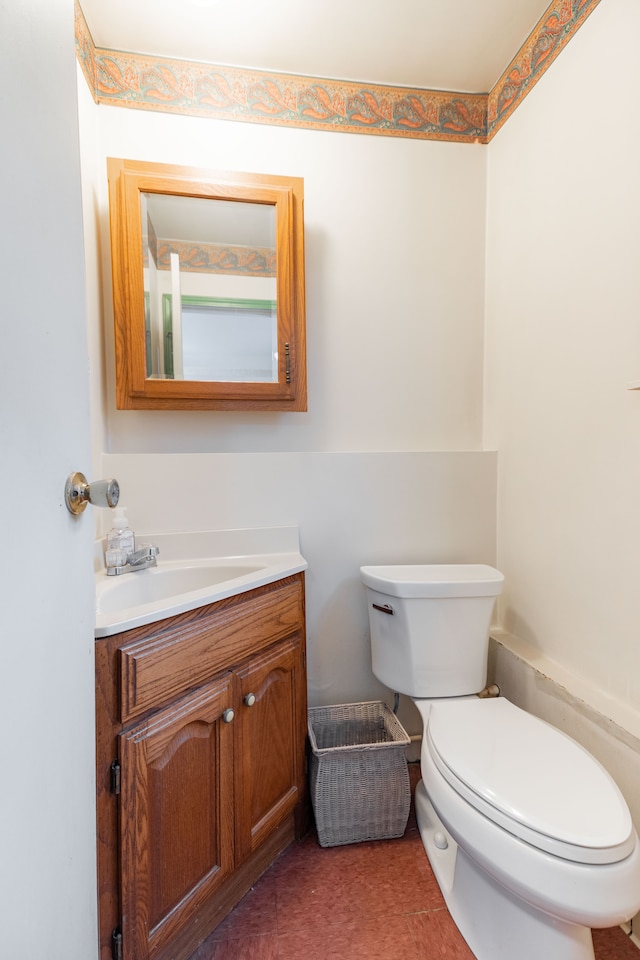 half bathroom featuring vanity and toilet