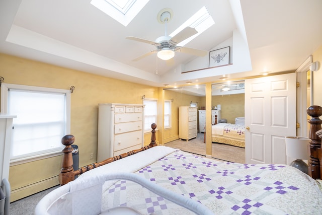 carpeted bedroom featuring vaulted ceiling with skylight and a baseboard radiator