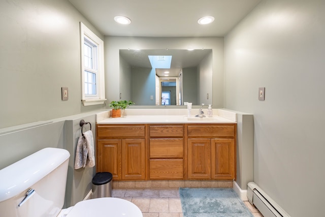 bathroom with vanity, a skylight, toilet, and a baseboard radiator