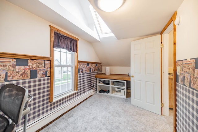 office with a baseboard heating unit, vaulted ceiling with skylight, carpet, and wainscoting