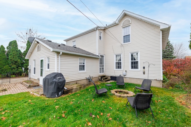 back of property featuring entry steps, a patio area, a fire pit, and a lawn