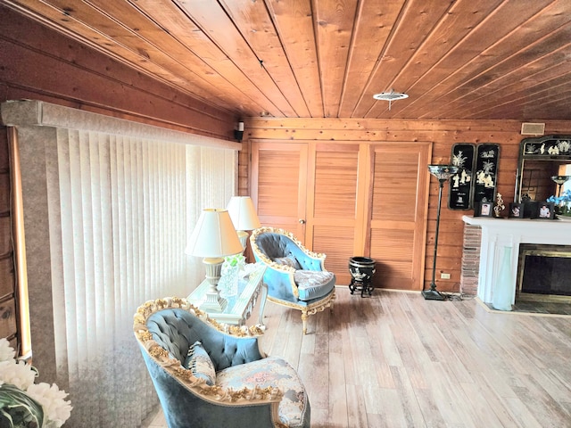 unfurnished room featuring a fireplace with flush hearth, wooden ceiling, wooden walls, and wood finished floors