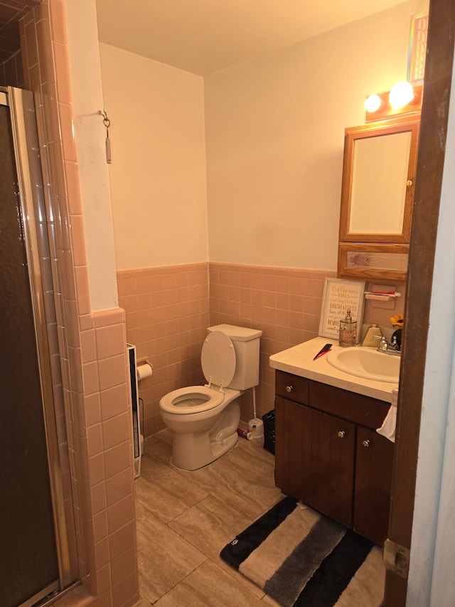 full bathroom with walk in shower, a wainscoted wall, toilet, and tile walls