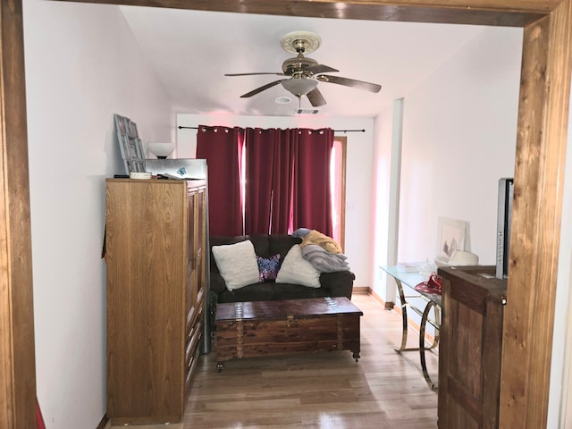 sitting room featuring baseboards, ceiling fan, and wood finished floors