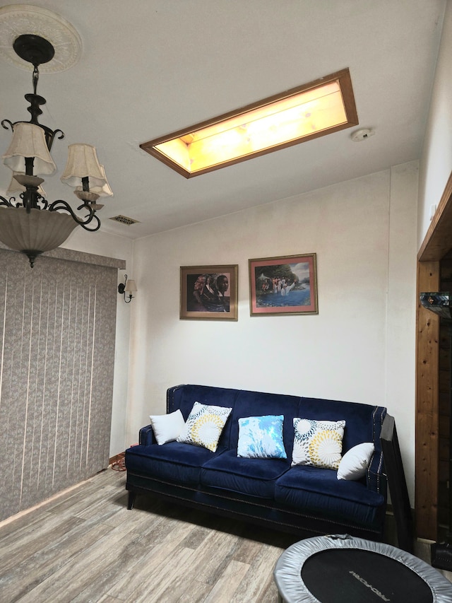 living area featuring lofted ceiling, wood finished floors, and visible vents