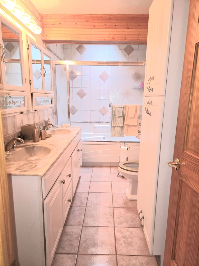 full bath with bath / shower combo with glass door, double vanity, toilet, and a sink