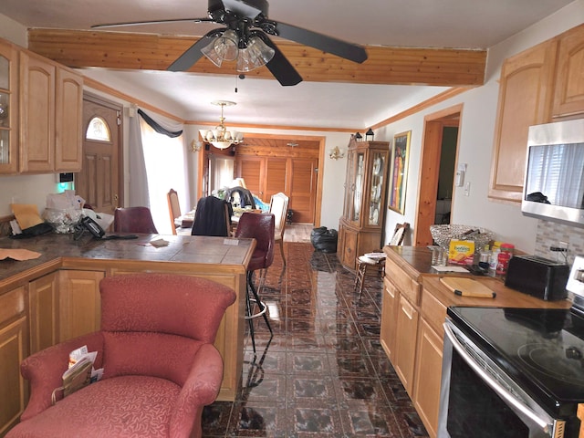 kitchen featuring light brown cabinets, tile counters, ceiling fan with notable chandelier, appliances with stainless steel finishes, and a peninsula