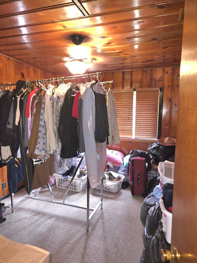 interior space with carpet, wood ceiling, and wood walls