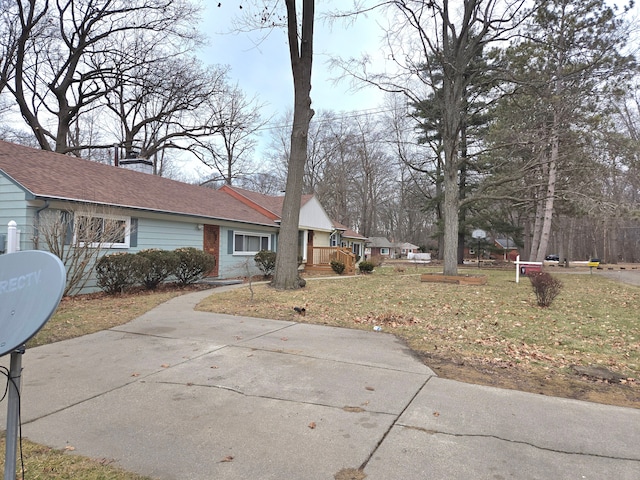 exterior space with brick siding, a chimney, a yard, and roof with shingles