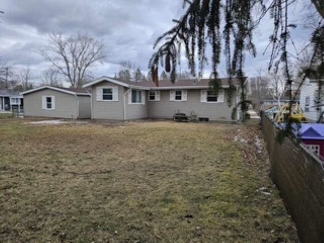 back of house featuring a yard and fence