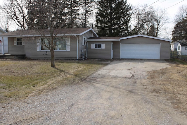 ranch-style house with an attached garage, driveway, and a front lawn