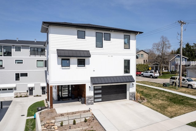 view of front of house featuring an attached garage, driveway, metal roof, and a standing seam roof