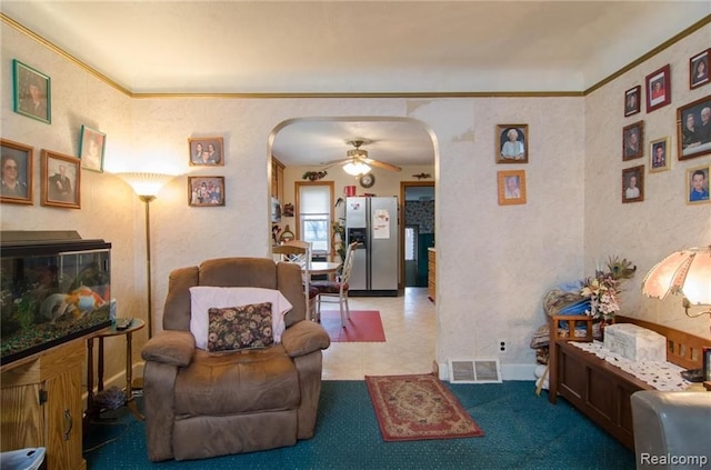 living room featuring arched walkways, visible vents, a fireplace, and ornamental molding