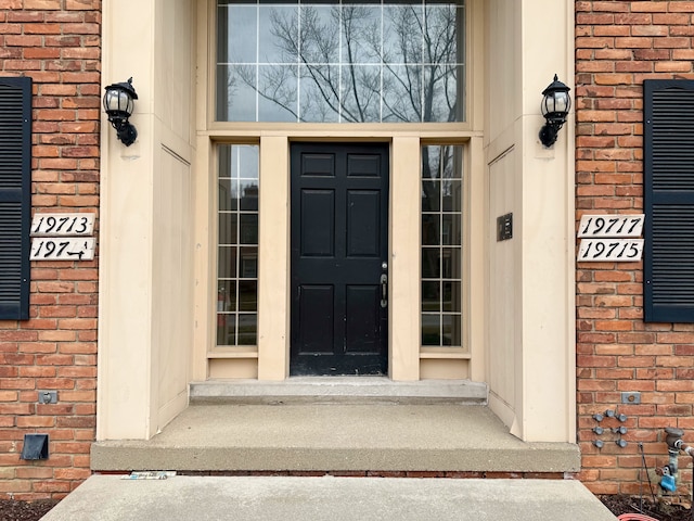 doorway to property featuring brick siding