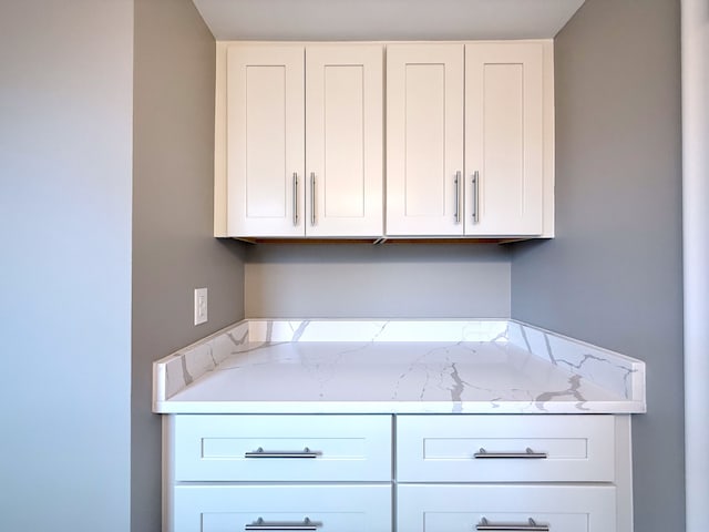 kitchen with light stone countertops and white cabinets