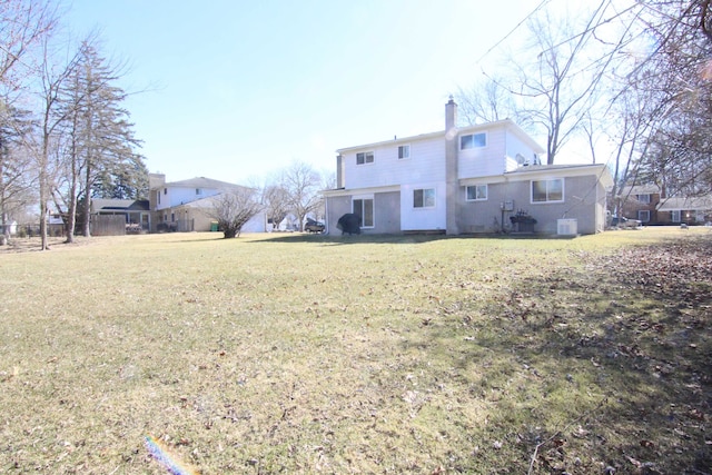 rear view of house with a yard and a chimney