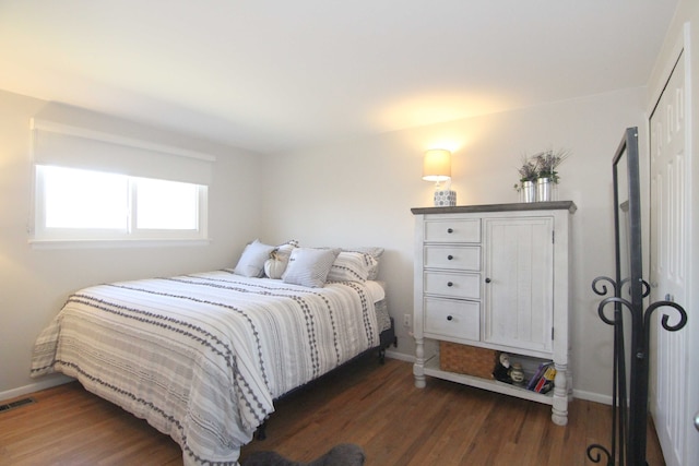 bedroom featuring visible vents, baseboards, and wood finished floors