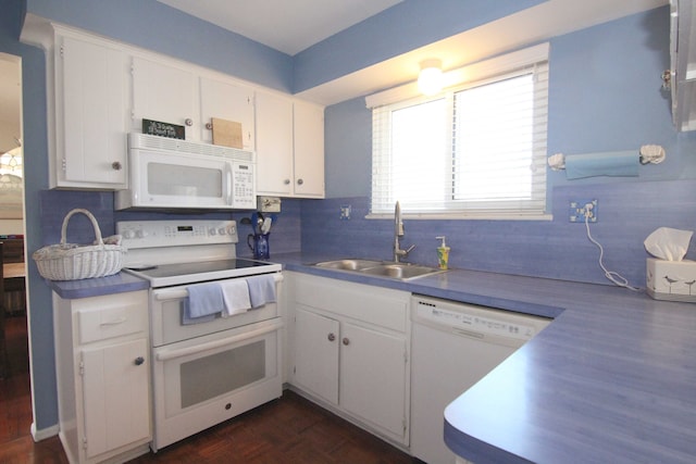 kitchen with white appliances, white cabinets, tasteful backsplash, and a sink