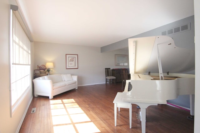 living area with visible vents, baseboards, and wood finished floors