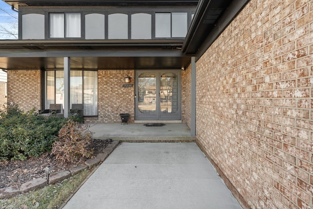 property entrance with brick siding and a porch