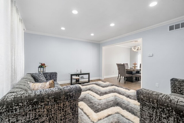 living area featuring recessed lighting, ornamental molding, baseboards, and wood finished floors
