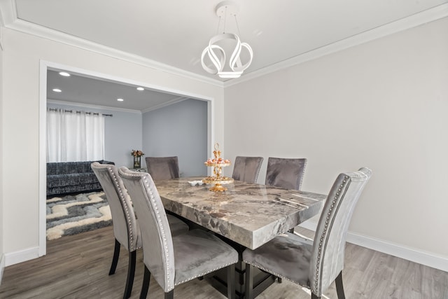 dining room featuring baseboards, wood finished floors, and crown molding