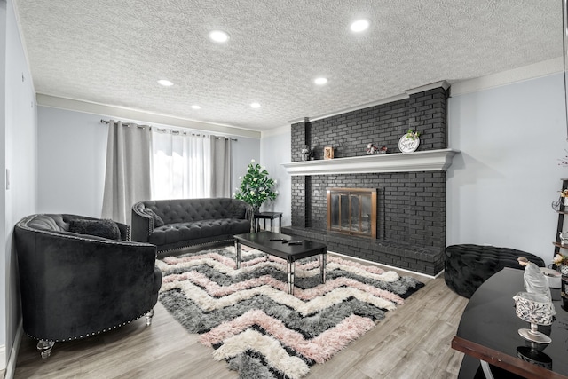 living room with a fireplace, recessed lighting, wood finished floors, and a textured ceiling