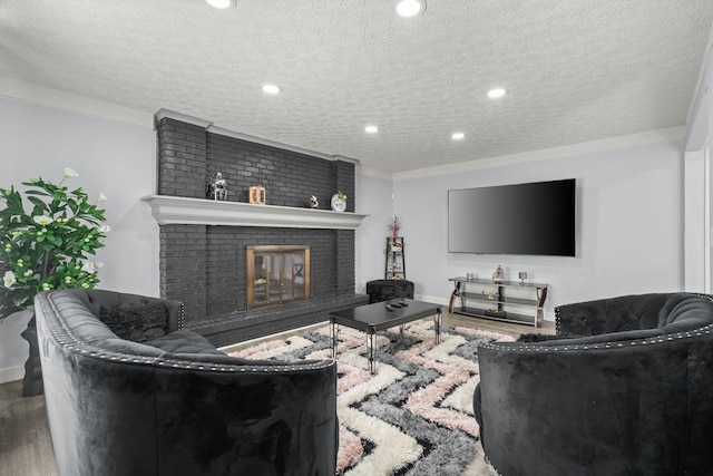 living room with recessed lighting, a textured ceiling, a brick fireplace, and wood finished floors