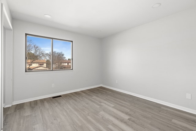 unfurnished room featuring recessed lighting, baseboards, and wood finished floors