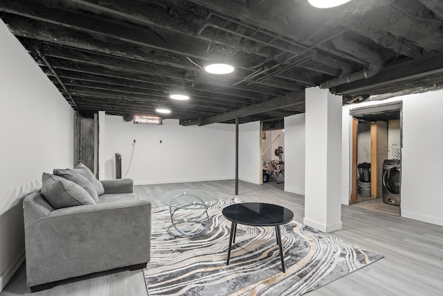 finished below grade area with washer / clothes dryer, wood finished floors, and baseboards
